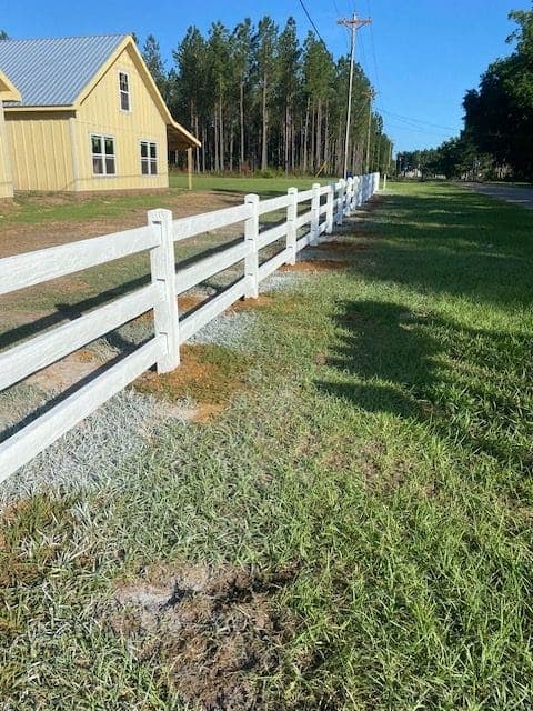 Concrete ranch rail fence installed on a horse farm property with open pasture, demonstrating the classic ranch aesthetic