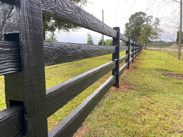Concrete ranch rail fence along a residential estate driveway, showcasing the decorative boundary application
